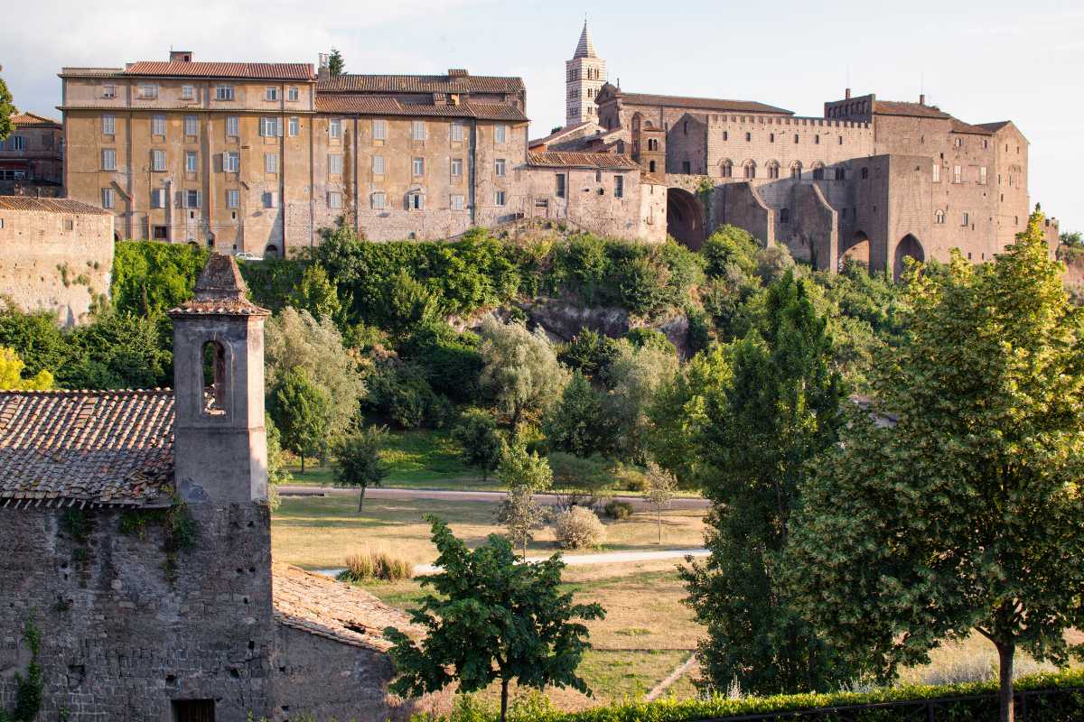 Vista panoramica del quartiere medievale di San Pellegrino a Viterbo, con bambini che giocano e famiglie in visita